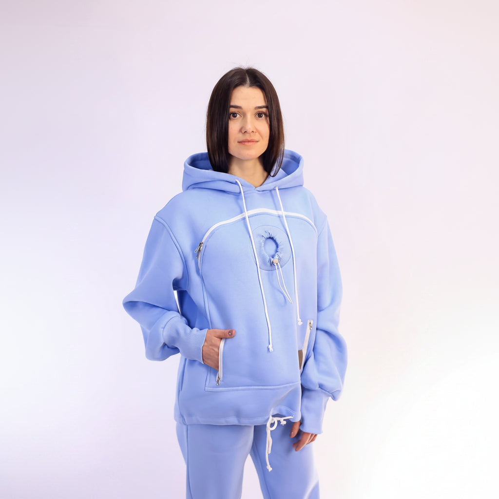Woman wearing a light blue tracksuit with white drawstrings on a white background