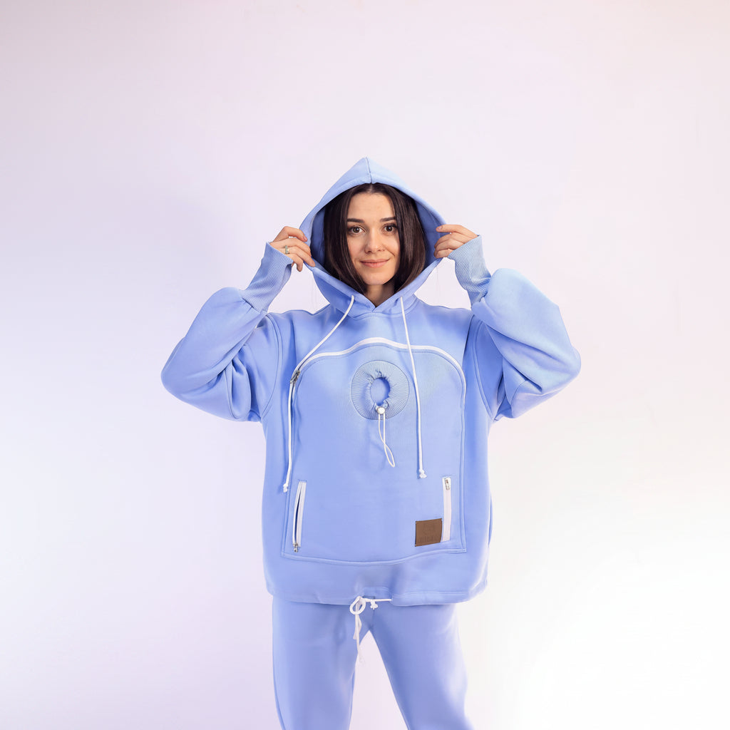 Person wearing a light blue hoodie and pants on a white background