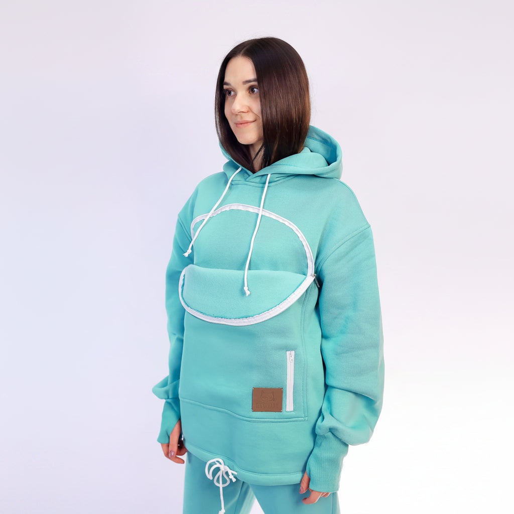 Person wearing a Mint Green hoodie with white accents on a light purple background