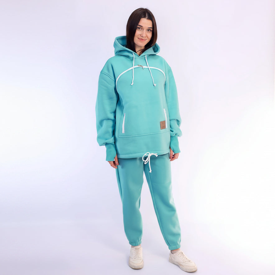 Person wearing a mint tracksuit on a white background