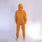 Person wearing a mustard tracksuit on a white background