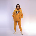 Person wearing a mustard hoodie and pants with a dog graphic on a white background
