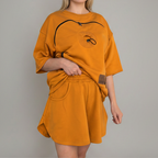 Person wearing an orange outfit with a plain background