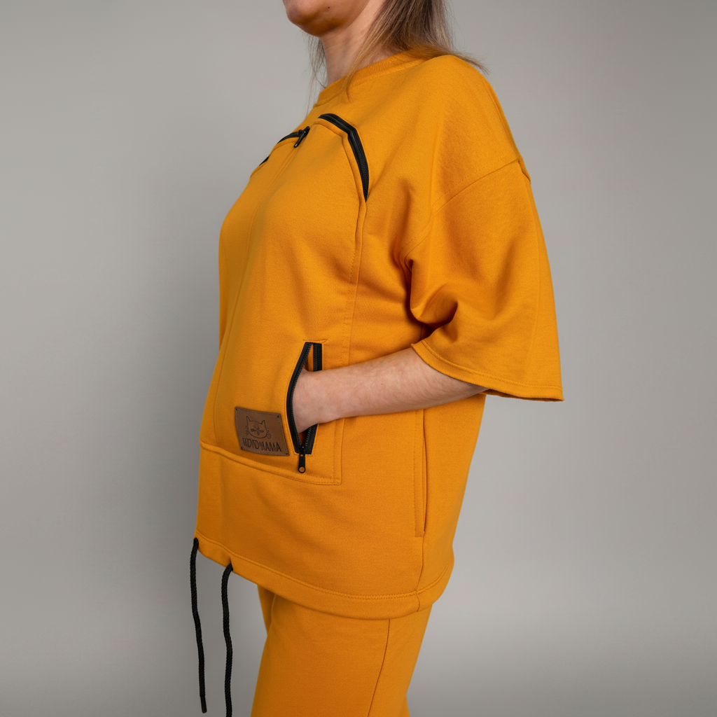 Person wearing a mustard yellow outfit with black accents on a plain background