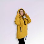 Person wearing a orange hoodie with black accents on a light purple background