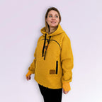 Woman wearing a orange fleece hoodie on a white background