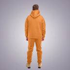 Person wearing a orange tracksuit on a white background