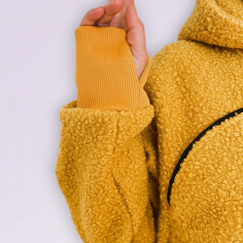 Person wearing a orange fleece hoodie with a white background