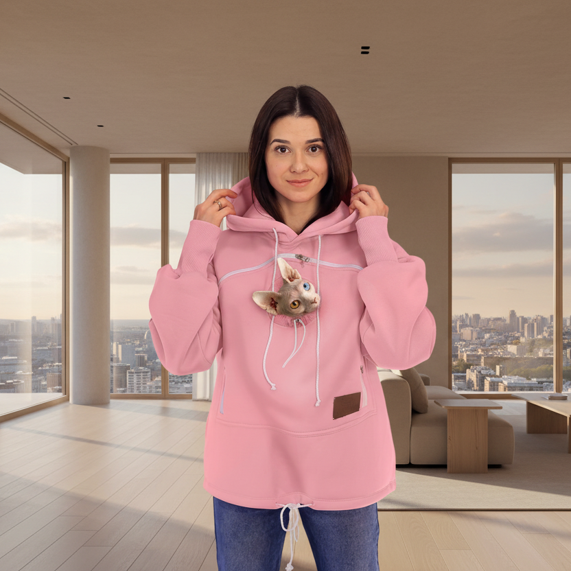 Woman wearing a pink hoodie with a cat design in a modern living room. Main image