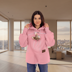 Woman wearing a pink hoodie with a cat design in a modern living room.