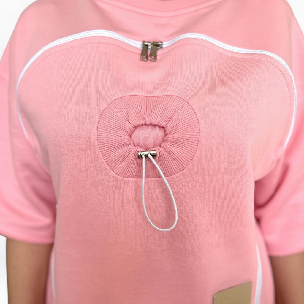 Close-up of a pink garment with a drawstring detail on a white background