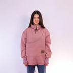 Person wearing a pink sweatshirt with a brand logo on a white background