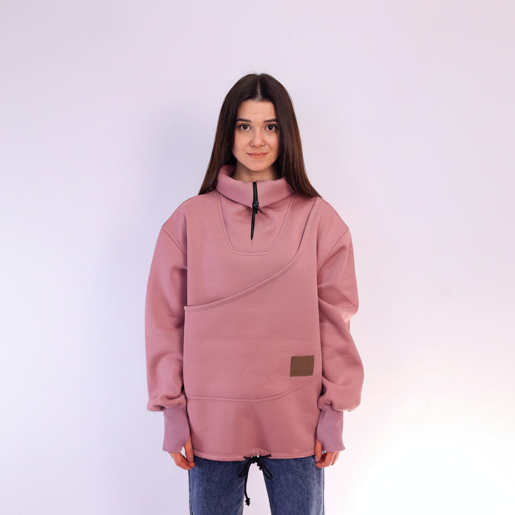 Person wearing a pink sweatshirt with a brand logo on a white background
