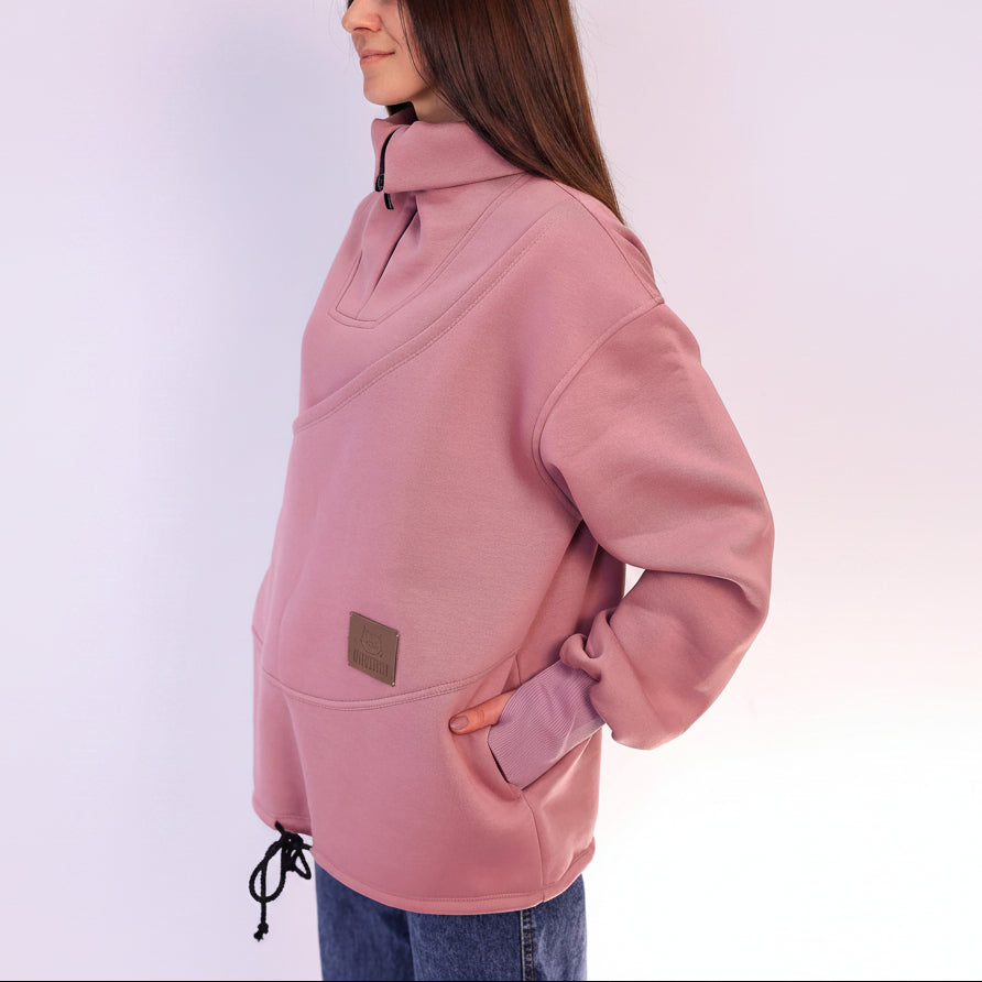 Person wearing a pink pullover with a high collar on a white background
