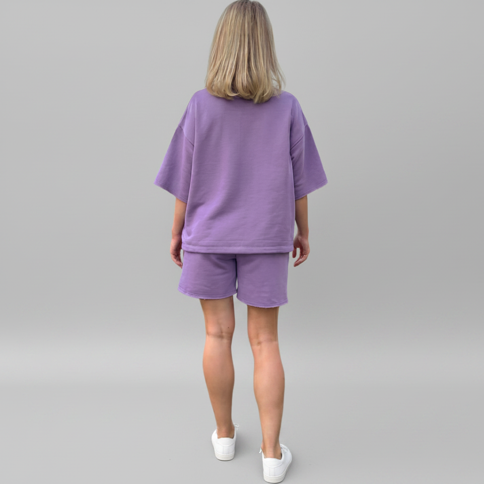 Person wearing a purple outfit on a gray background