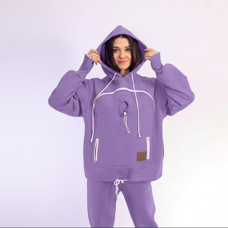 Person wearing a purple hoodie with white drawstrings on a light purple background