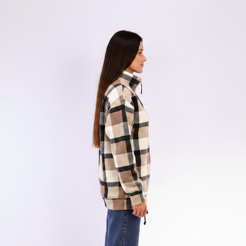 Woman wearing a beige plaid sweatshirt on light background