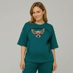 Woman wearing a teal t-shirt with a dog on a plain background