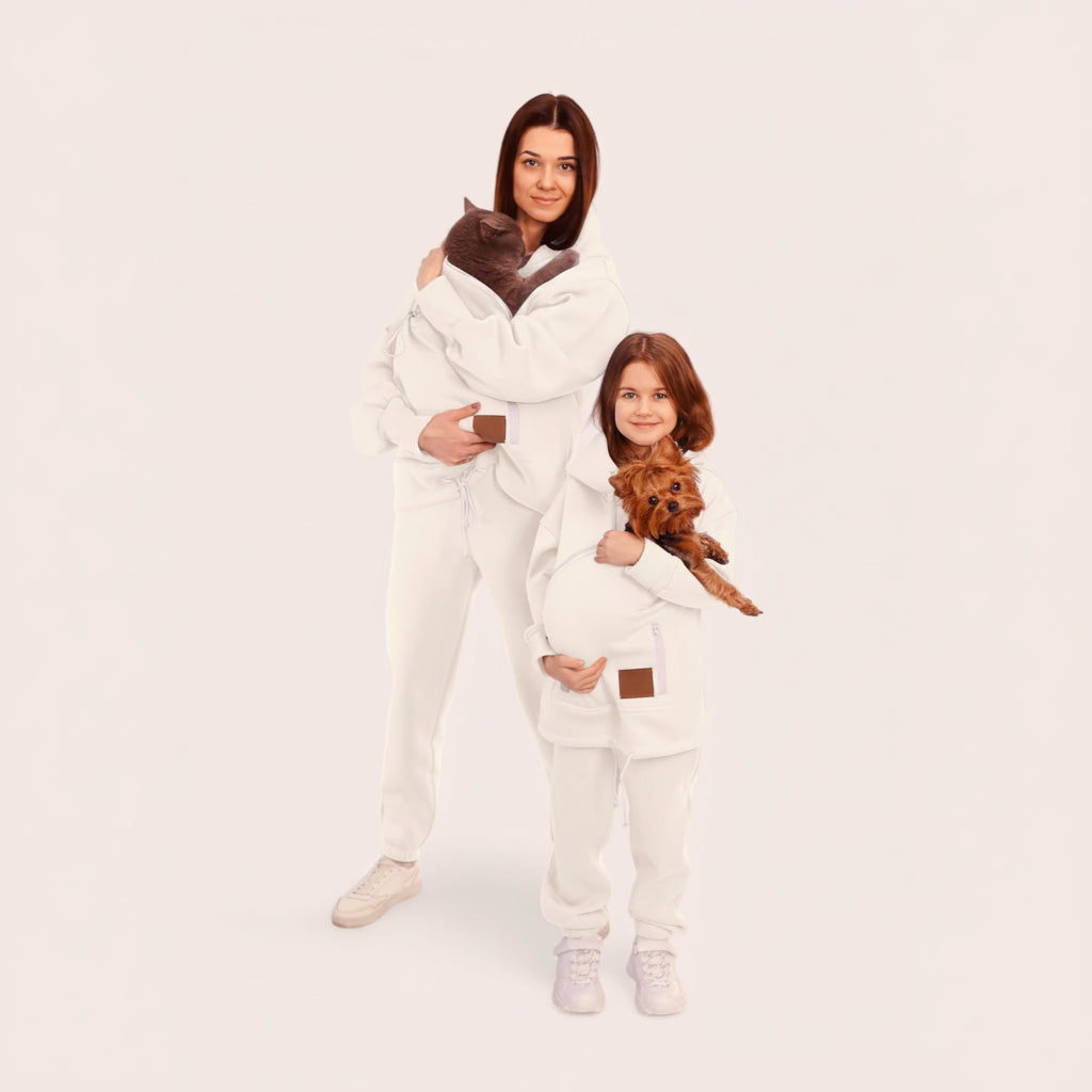 Two people in matching white set holding small dogs on a plain background Основне зображення