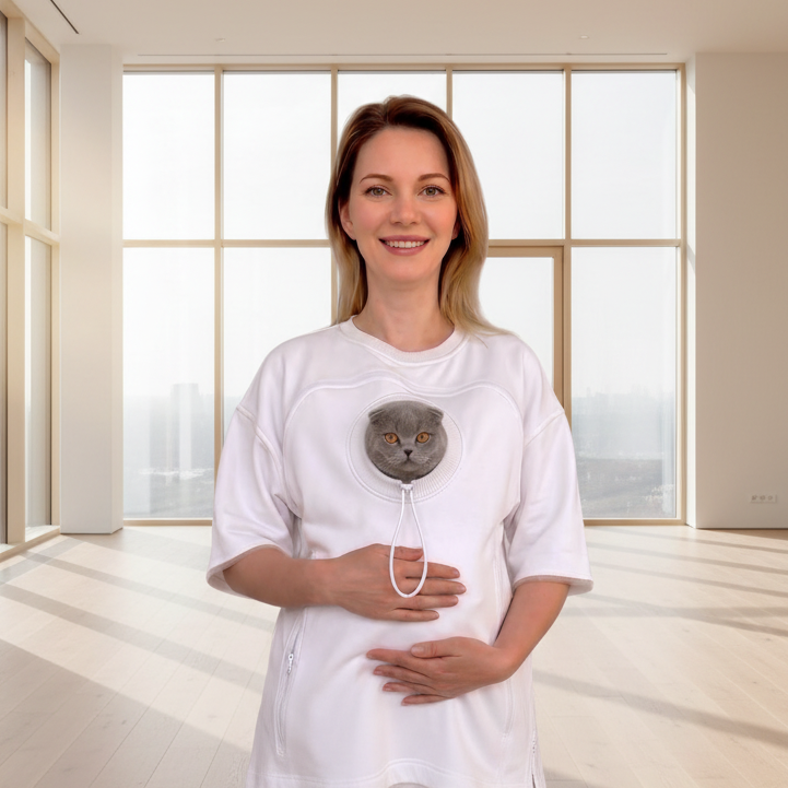 Woman wearing a white outfit with a cat face, standing in a room with large windows. Основне зображення