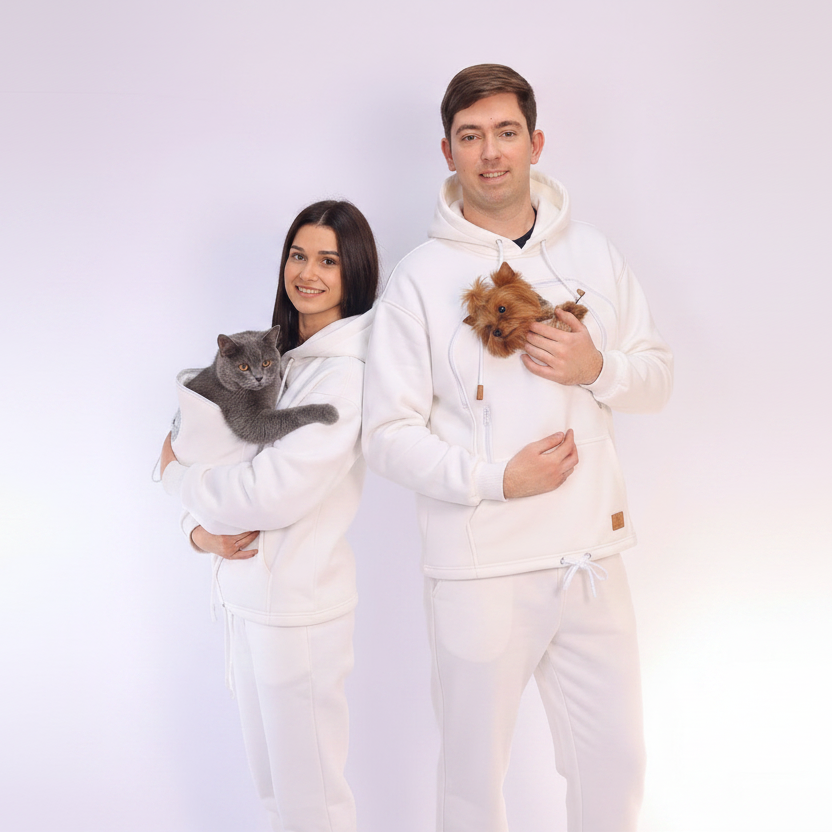 Two people wearing matching white outfits with animals, standing against a plain background.