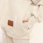 White hoodie with a brown patch and white zipper on a light gray background