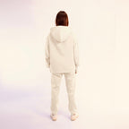 Person wearing a white  hoodie and pants set on a white background