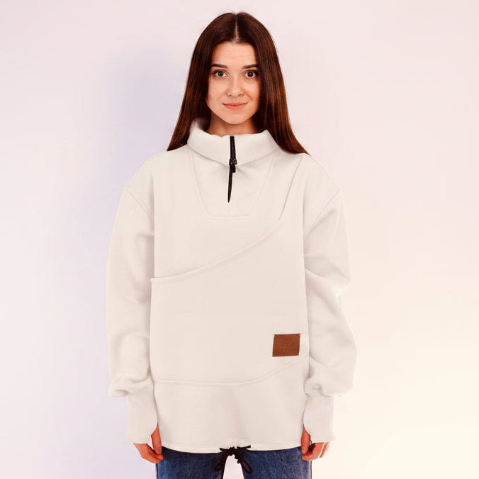 Person wearing a white fleece sweatshirt with a brown patch on a light pink background