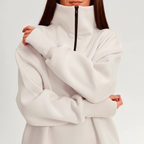 Person wearing a white sweatshirt on a light pink background