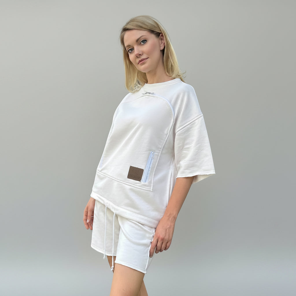 Woman wearing a white outfit with a brown patch on a gray background