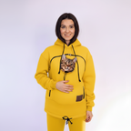 Person wearing a yellow hoodie with a cat face on a white background