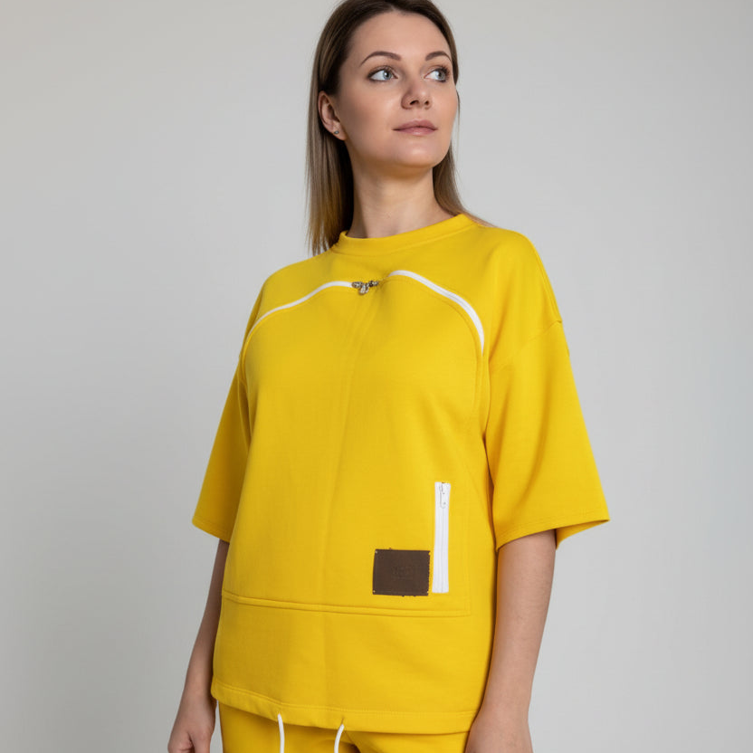 Woman wearing a yellow outfit with a brown pocket on a plain background