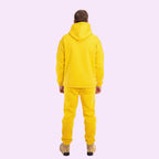 Person wearing a yellow tracksuit on a white background