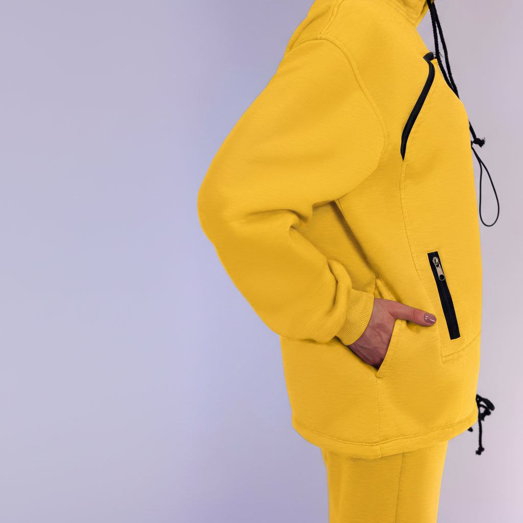 Yellow tracksuit with black drawstrings on a light purple background