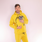 Person wearing a yellow hoodie and pants holding a gray cat on a white background