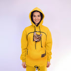 Person wearing a yellow hoodie with a cat peeking out of the pocket against a white background