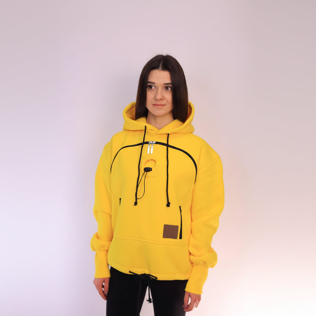 Person wearing a yellow hoodie with black drawstrings on a white background