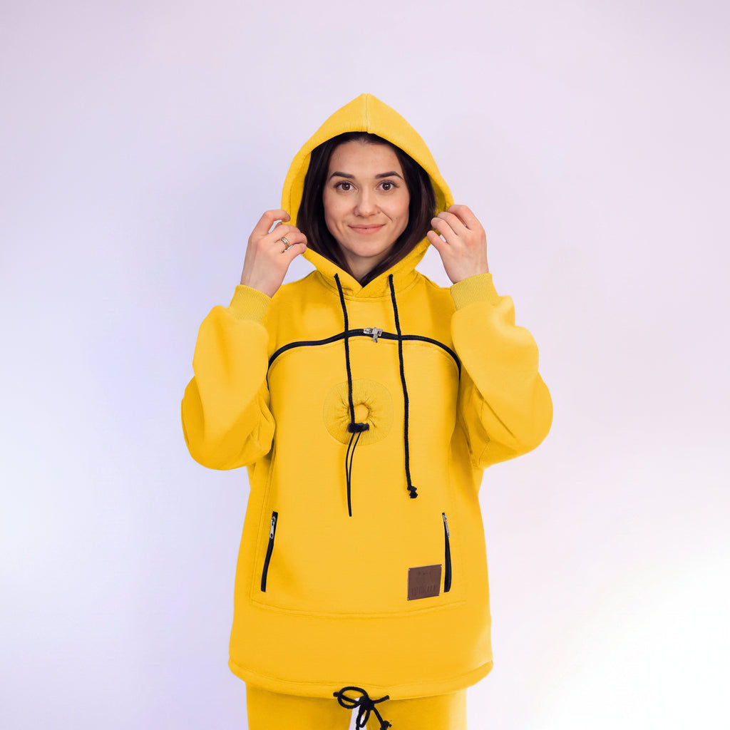 Person wearing a yellow hoodie with a plain background
